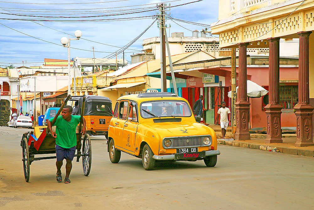 Véhicule et pousse-pousse dans une rue de Diego Suarez